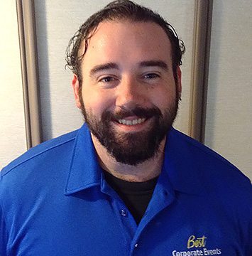 A man in a blue shirt with a beard.