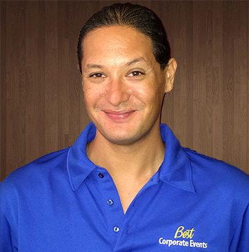 A man in a blue shirt smiling at the camera.