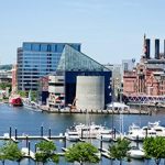 A boat docked in a harbor with buildings in the background.