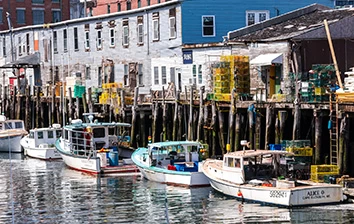 A group of boats docked at a dock in a harbor.
