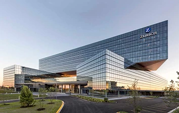 A large glass building with a blue sky in the background.