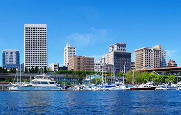 Team Building in a city with tall buildings and boats docked in the water.