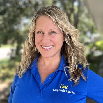 A smiling woman in a blue polo posing for a photo.