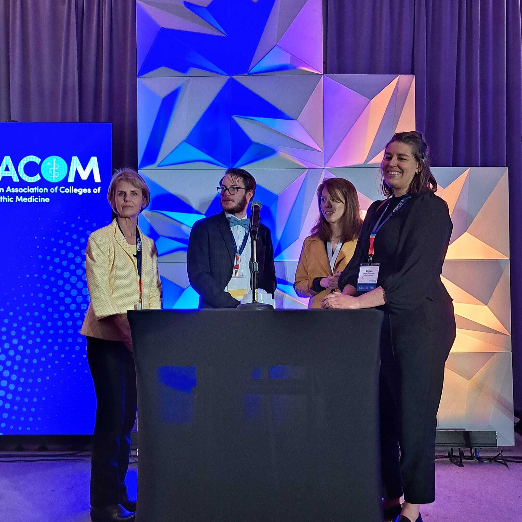 A group of people standing in front of a table.