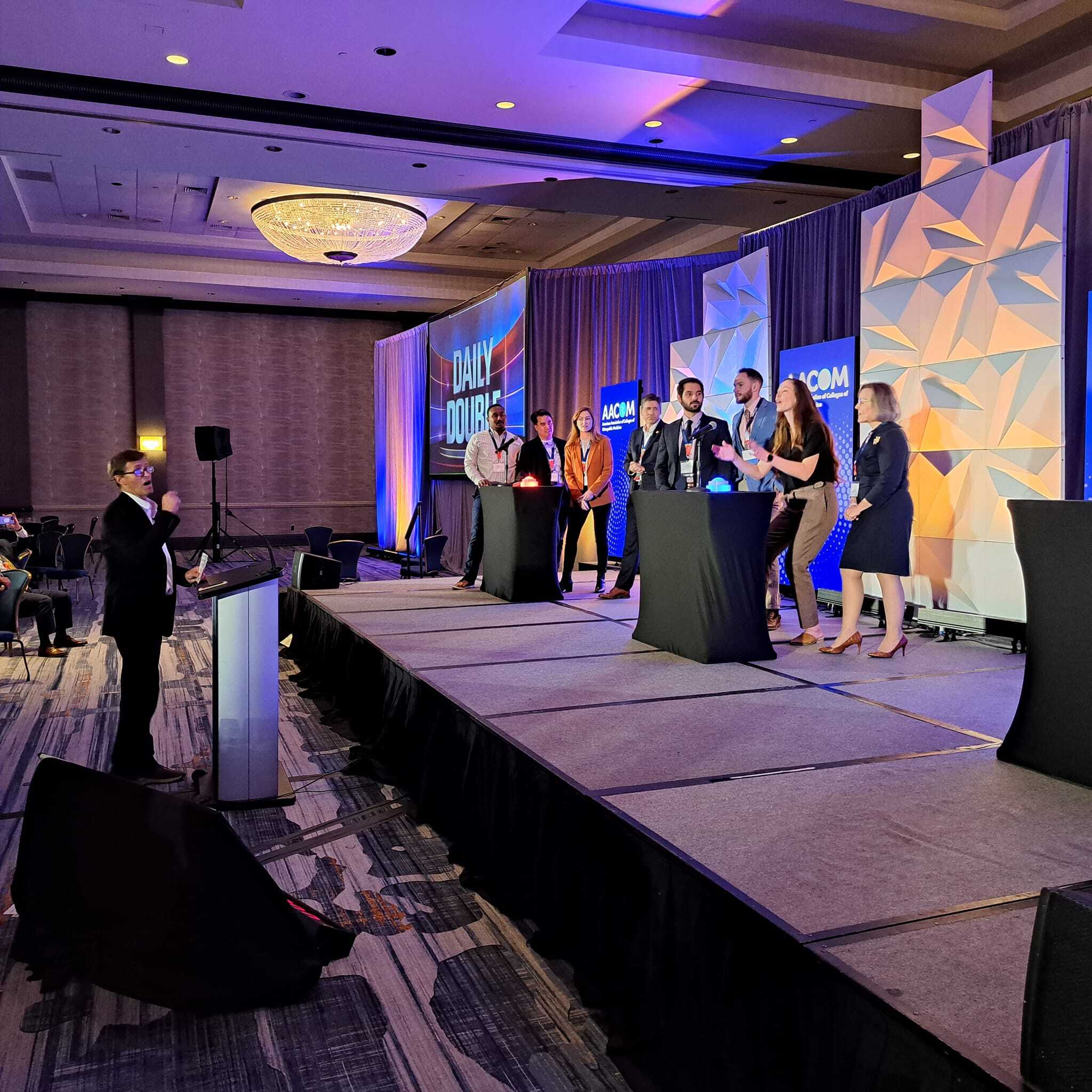A group of people standing on stage at an event.