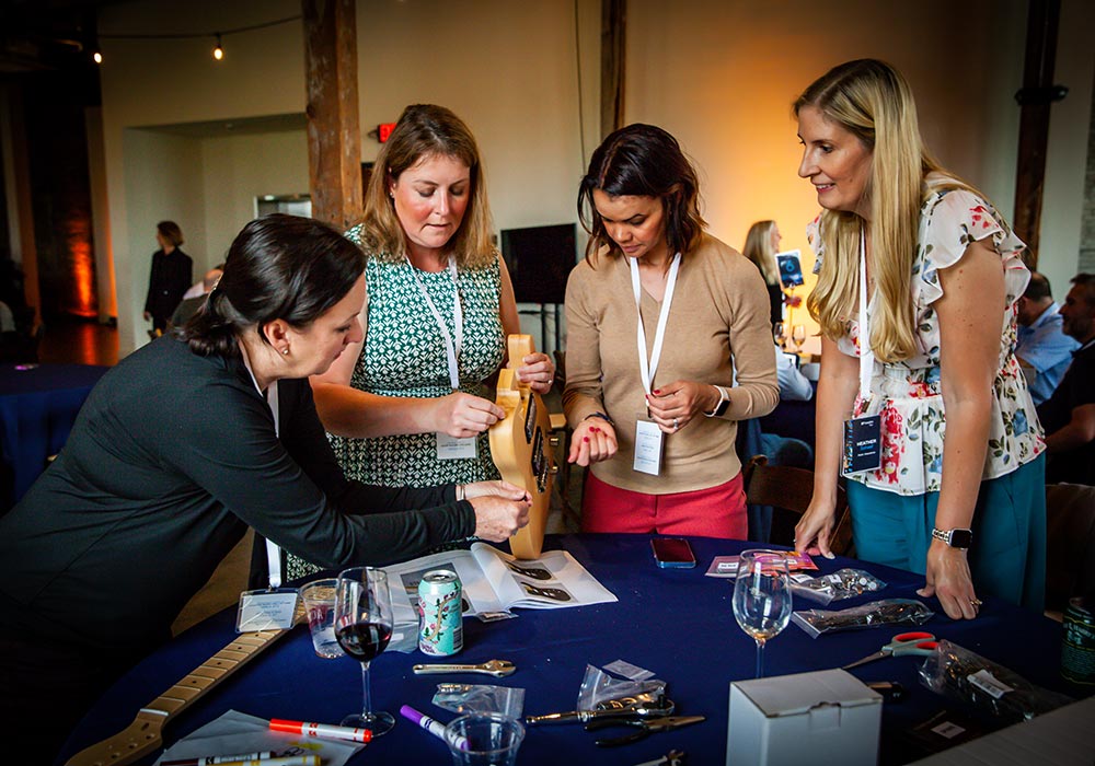 Four women standing around a table.
