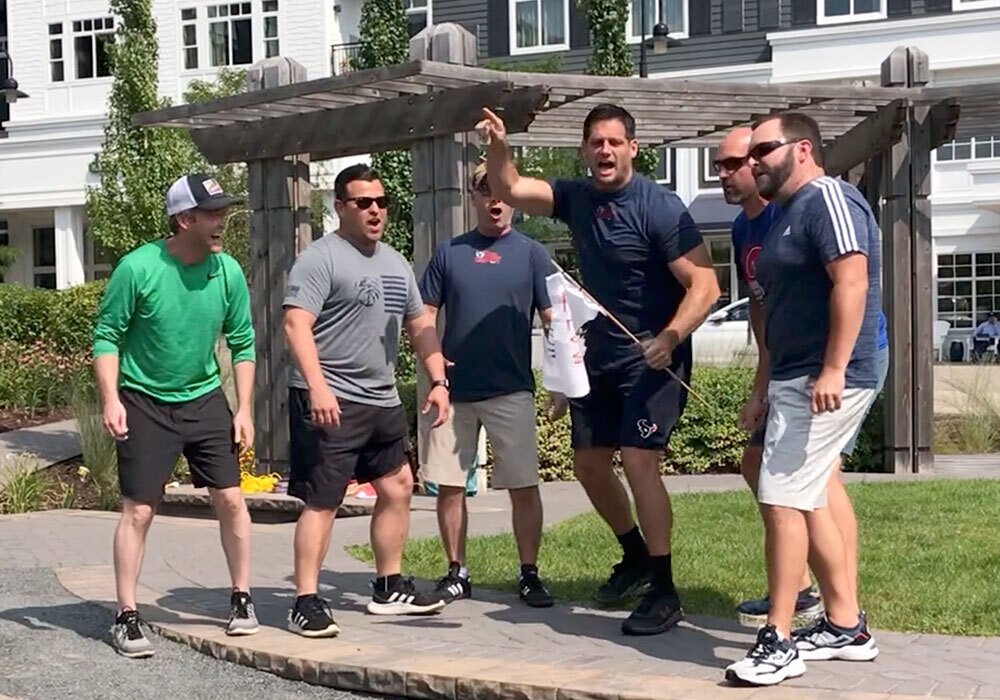 A group of men standing in front of a house.