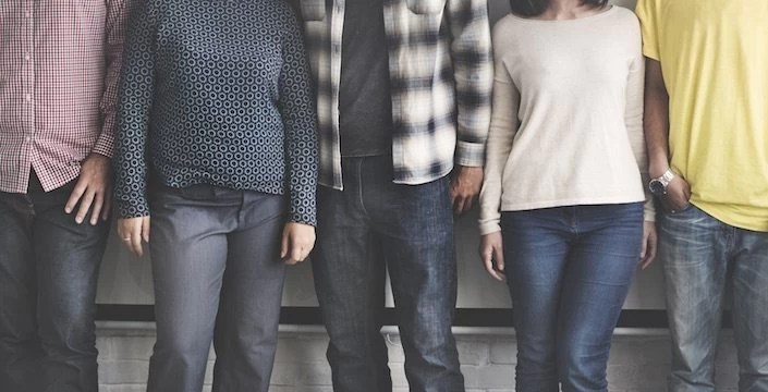 A group of people standing in front of a wall.
