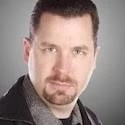 A man in a black jacket is posing for a photo.