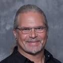 A man wearing glasses and a black shirt.