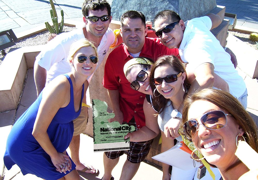 A group of people posing for a picture in front of a statue.