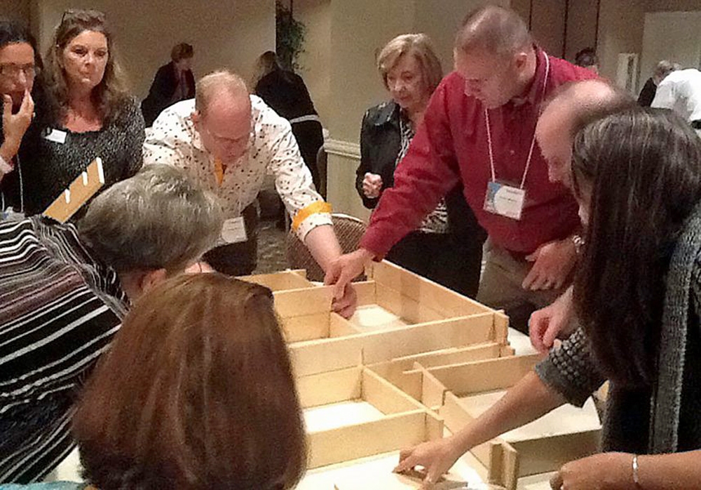 A group of people standing around a table.
