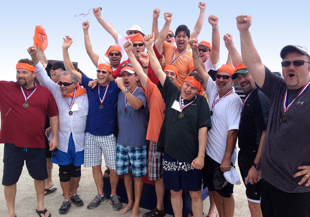 A group of people posing for a picture on the beach.
