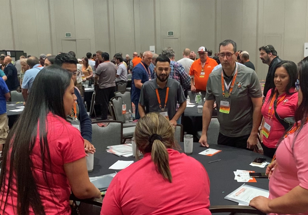 A group of people in pink shirts standing around a table.