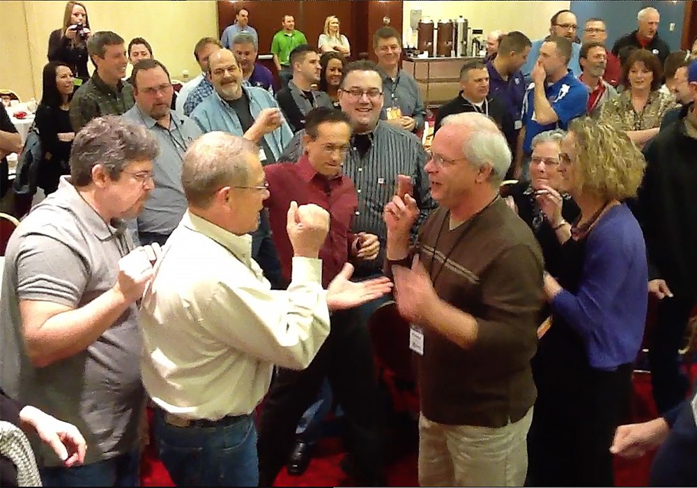 A group of people standing around in a room.