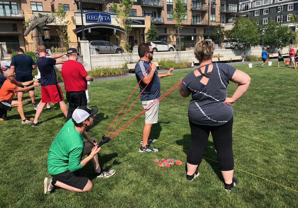 A group of people standing on a grassy area with ropes.