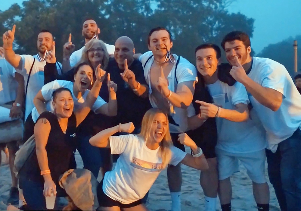 A group of people posing for a photo on the beach.