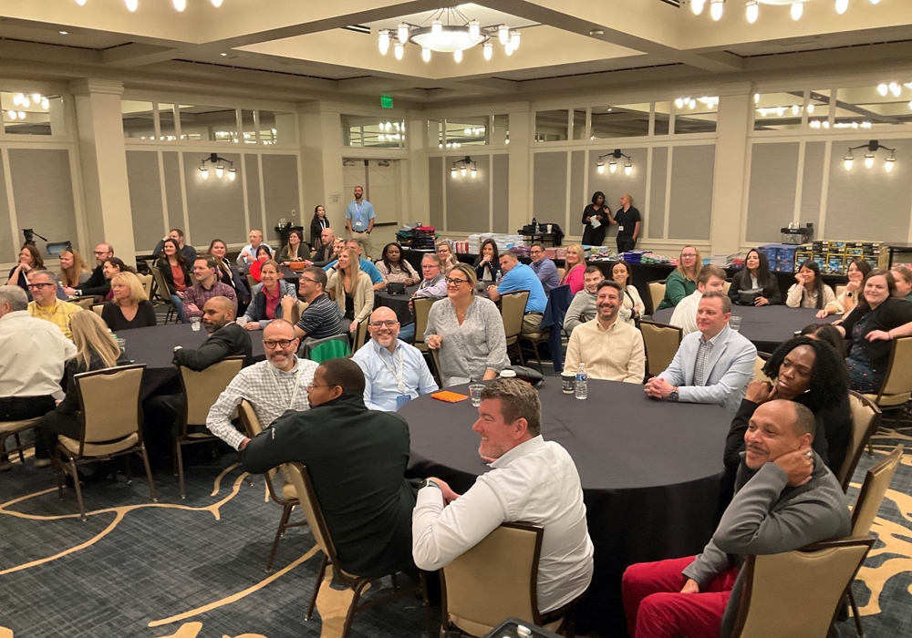 A large group of people sitting at tables in a room.