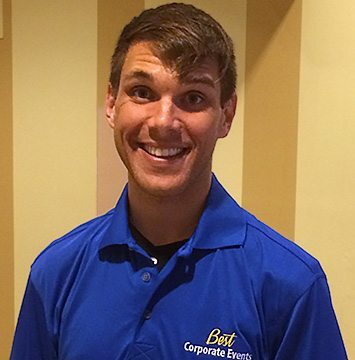 A young man in a blue polo shirt smiling.