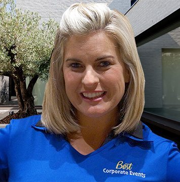 A woman in a blue shirt standing in front of a building.