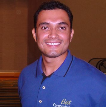 A man in a blue shirt smiling for the camera.