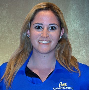 A woman in a blue shirt smiling at the camera.