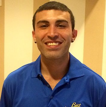 A man in a blue shirt smiles for the camera.