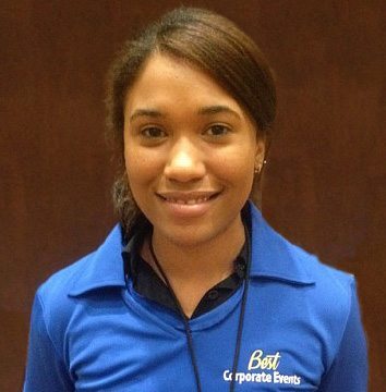 A young woman in a blue shirt smiling for the camera.