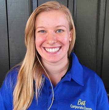 A smiling woman wearing a blue shirt and headphones.