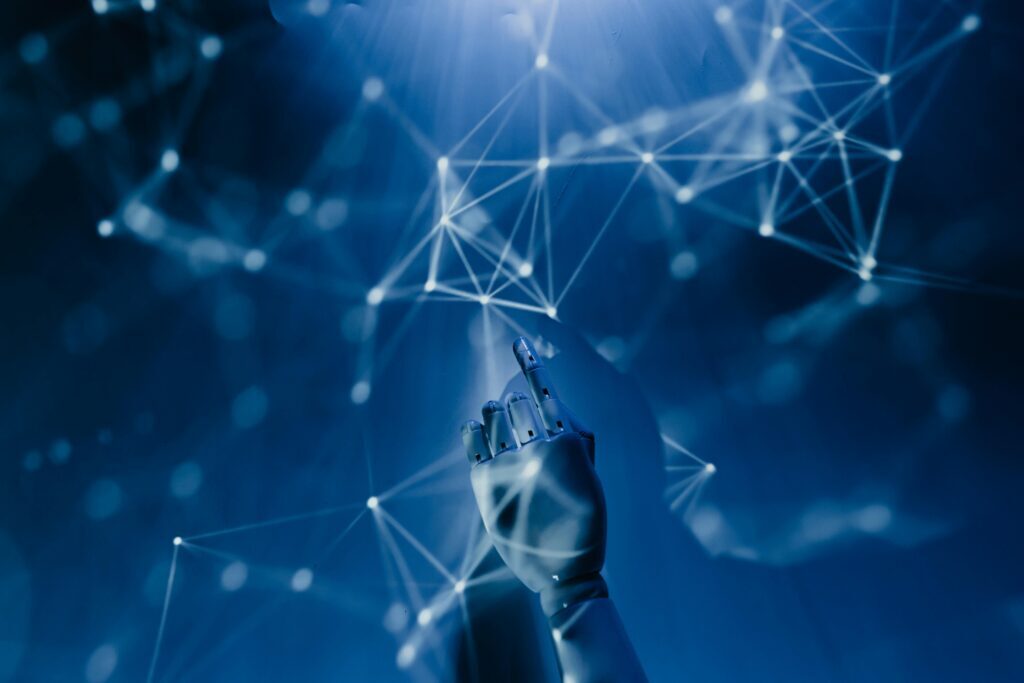 A robotic hand points toward a network of interconnected glowing nodes and lines against a blue background, symbolizing technology, digital connectivity, and raising employee AI concerns.