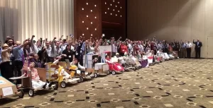 A group of people posing for a picture in front of a large room.