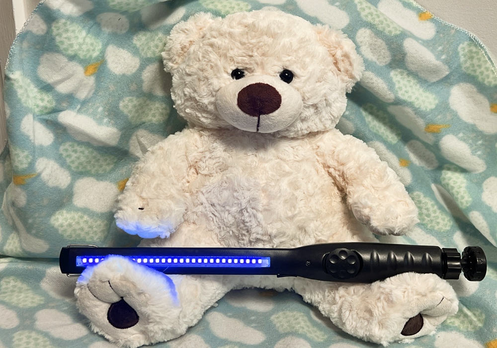 A teddy bear sitting on a blanket.