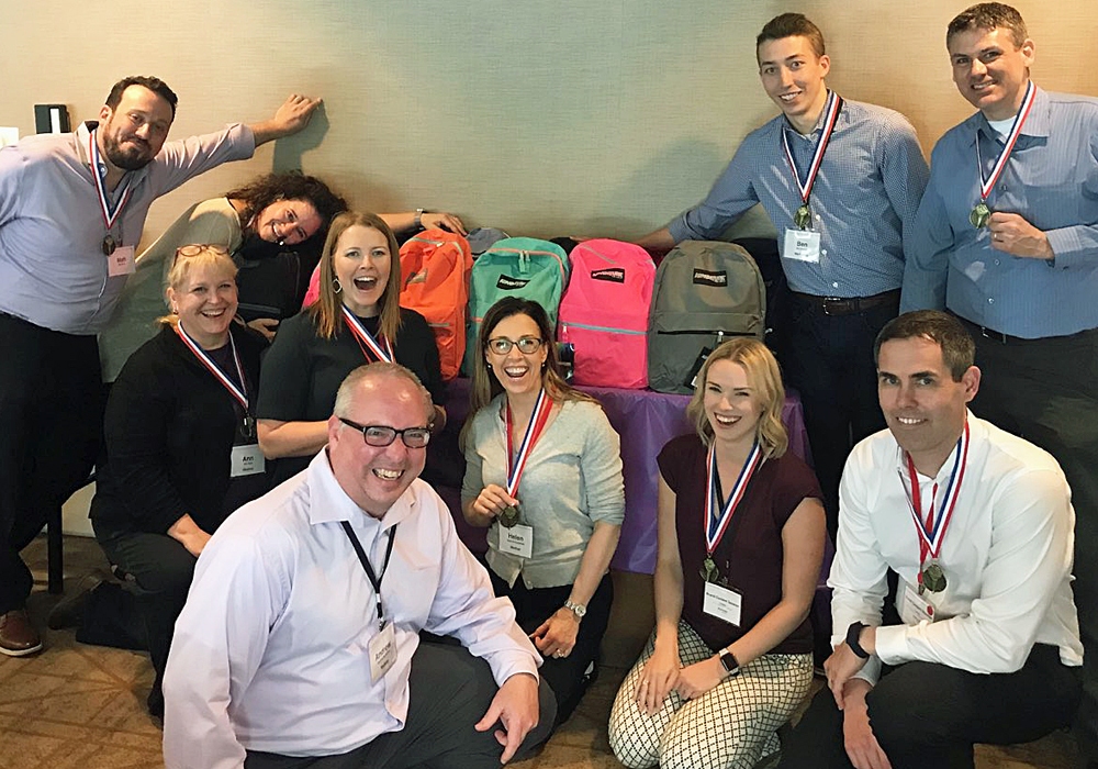 A group of people posing for a photo with their medals.