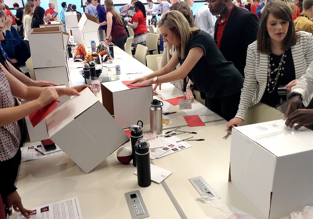 A group of people standing around a table with boxes.