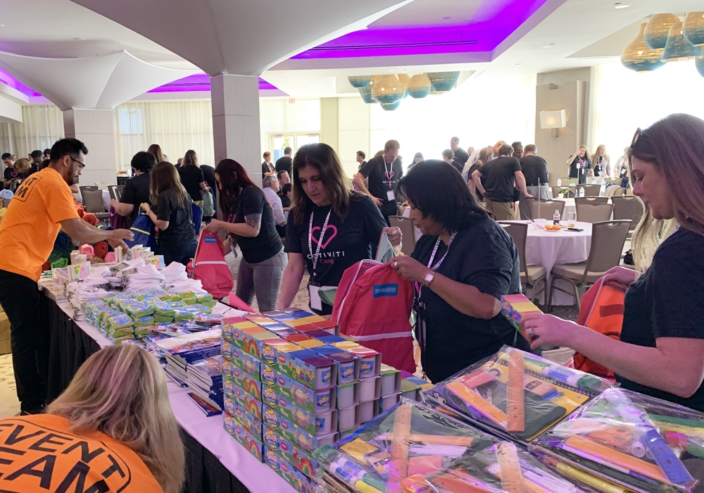 A group of people standing around a table full of books.