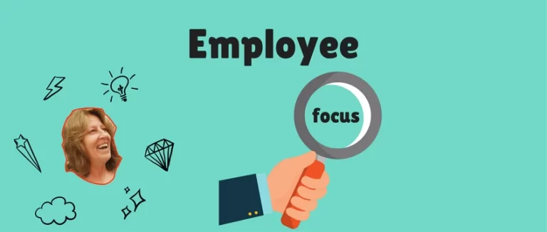 A hand holding a magnifying glass, emphasizing employee focus.