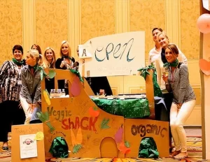 A group of people cooking in front of a cardboard sign.