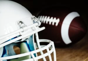 A Super Bowl-themed american football helmet and ball display on a wooden table.
