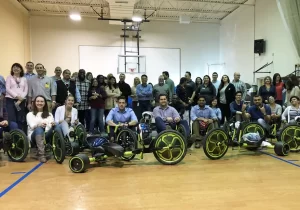 A groups of people posing for a picture in a gym, displaying their impressive size.