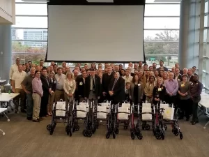 A group of people posing for a picture in front of a projector.