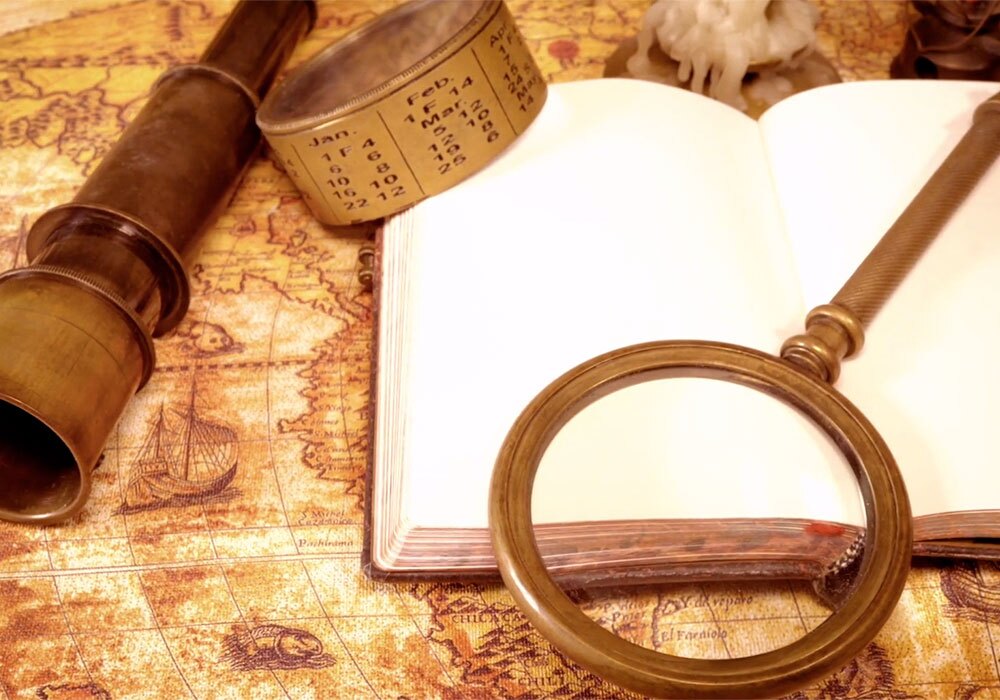 A book, a magnifying glass and a book on a map.