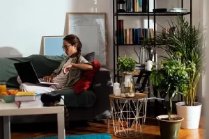 A woman sitting on a couch using a laptop.