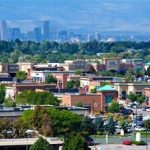 An aerial view of a city in colorado with mountains in the background.