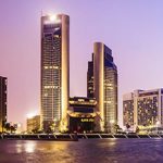 A view of a city at dusk with tall buildings in the background.