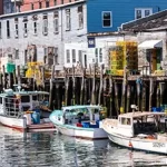 A group of boats docked at a dock in a harbor.