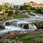 A team building activity at a city park in Sioux falls with a beautiful view of a waterfall.