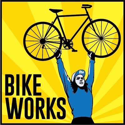 Illustration of a person in a blue shirt and cap lifting a bicycle overhead against a yellow background with rays. The words "BIKE WORKS" are on the left side.
